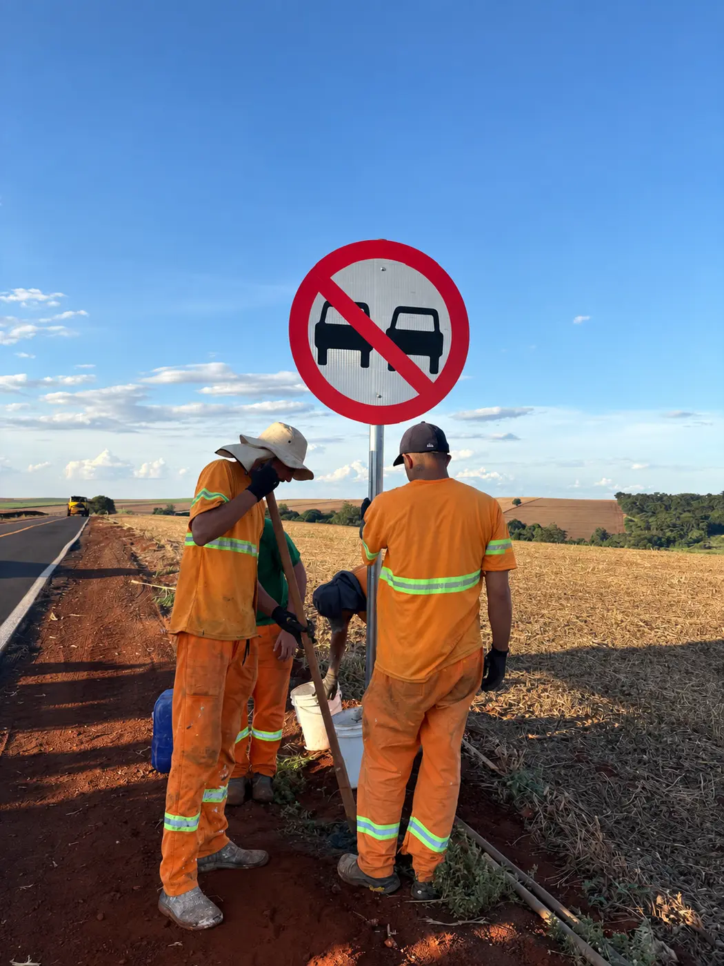 Equipe instalando placa de regulamentação em rodovia