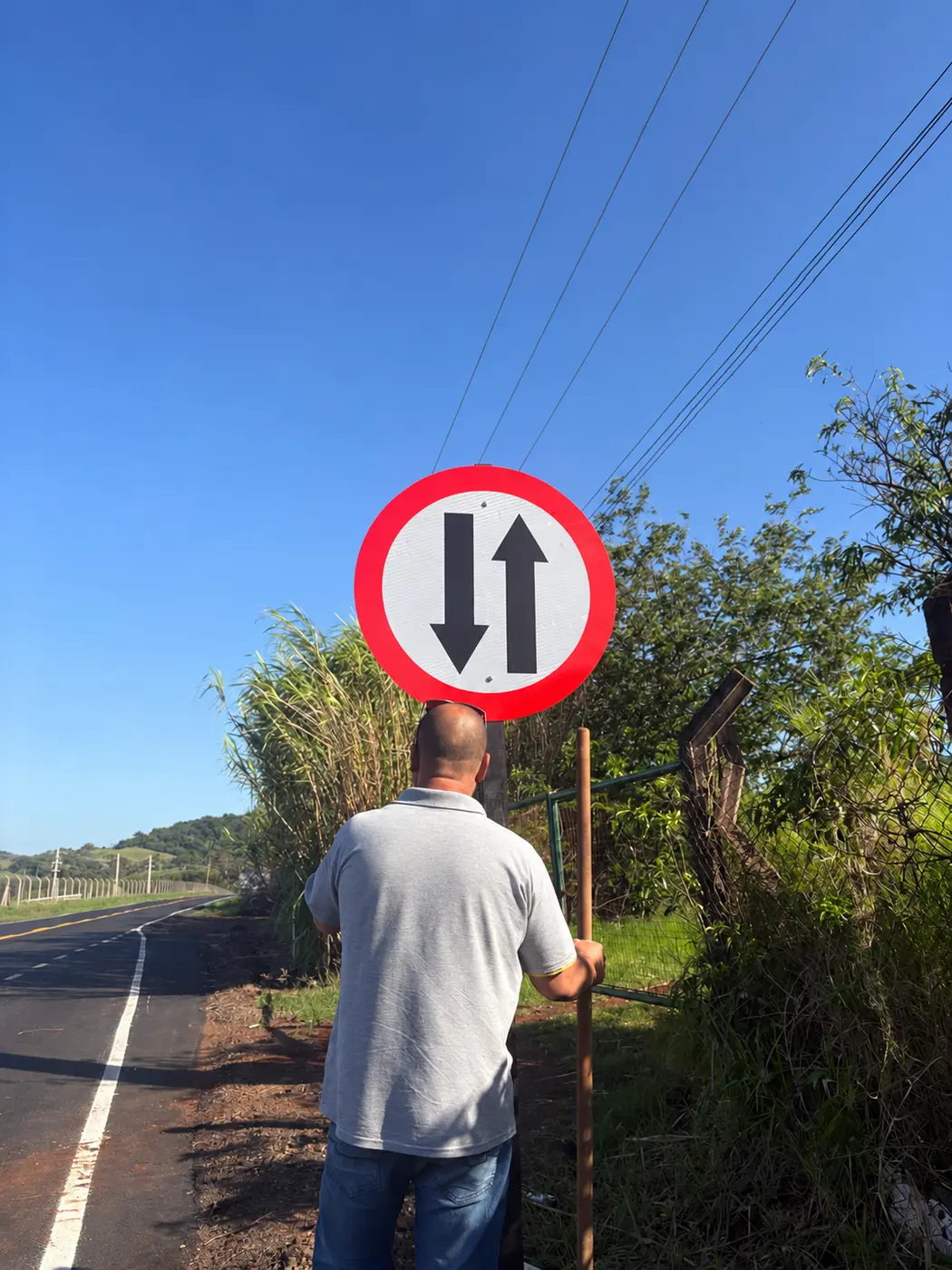 Equipe realizando instalação de placa em via